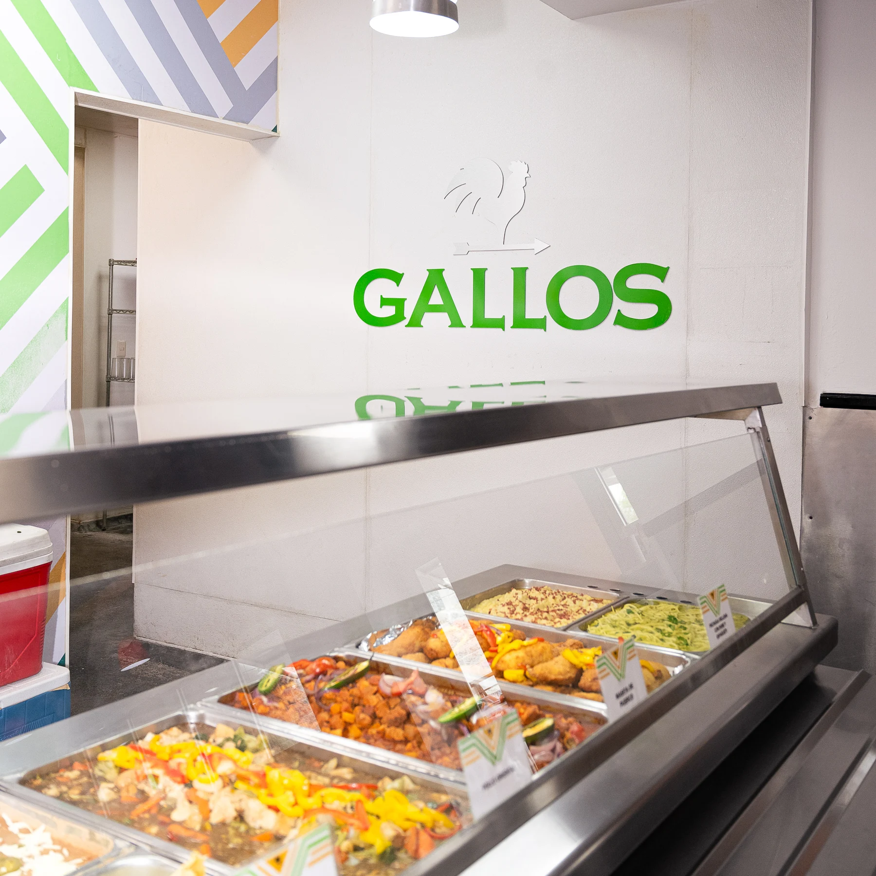 Barra de alimentos y letrero de Los Gallos